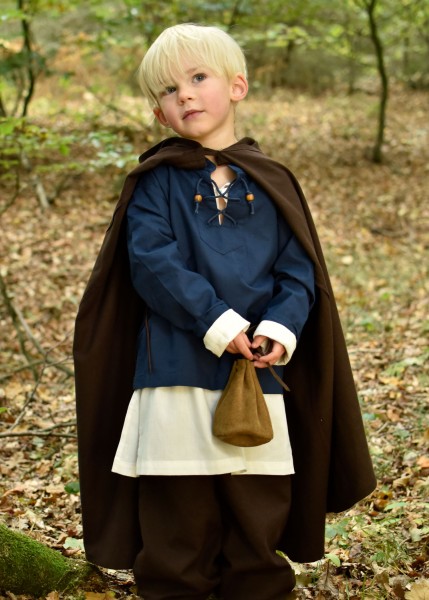 Ein Kind trägt einen braunen Mittelalter Umhang namens Paul im Wald. Der Umhang endet unter den Knien und wirkt robust. Ideal für Rollenspiele und Kostüme, bietet er Schutz und Stil.